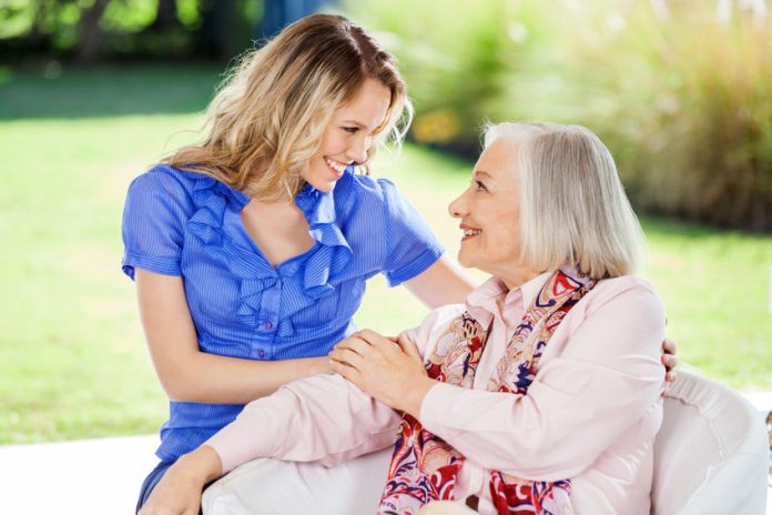 Affectionate Granddaughter And Grandmother At Nursing Home Porch