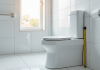 Salle de bain moderne accessible avec WC surélevé et lumière naturelle
